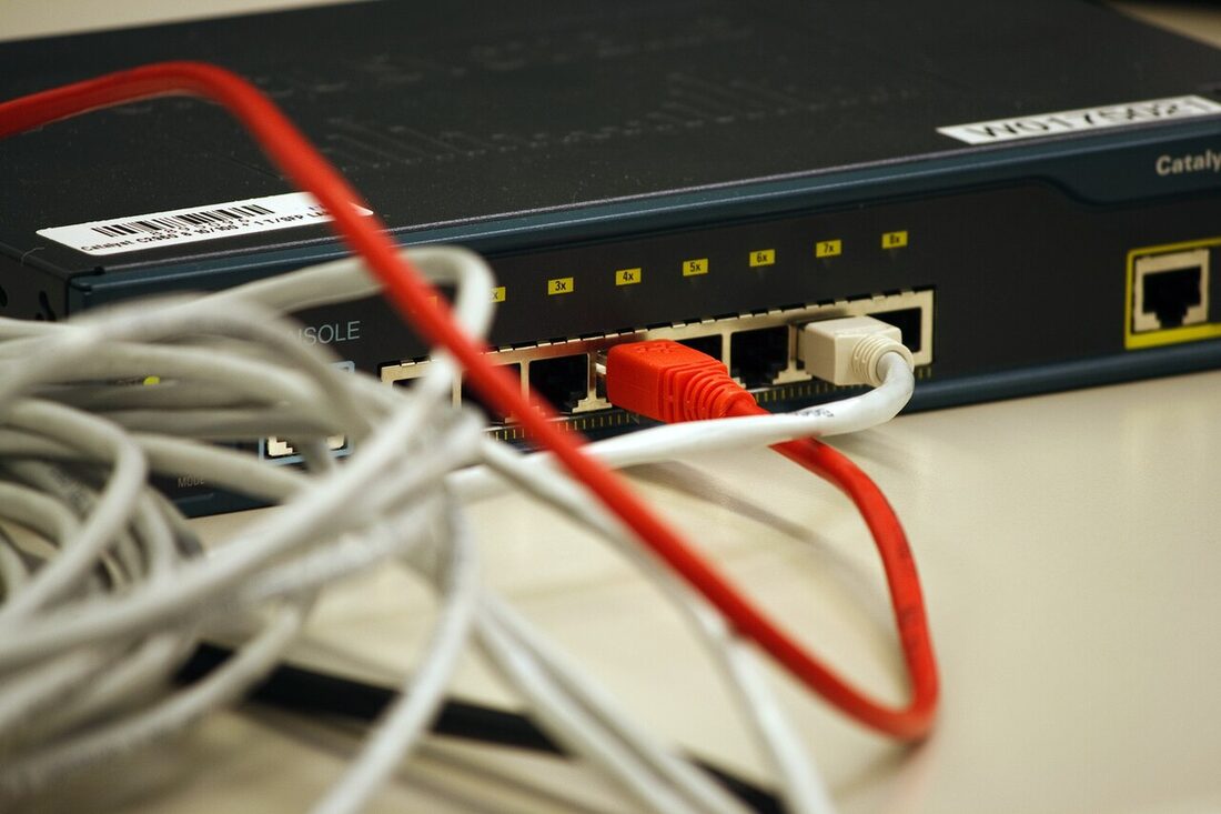 Un switch réseau devant un écheveau de câbles enroulés en vrac
